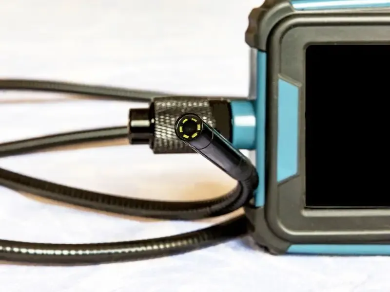 Caméra d'inspection pour plomberie avec un câble flexible et un écran intégré.