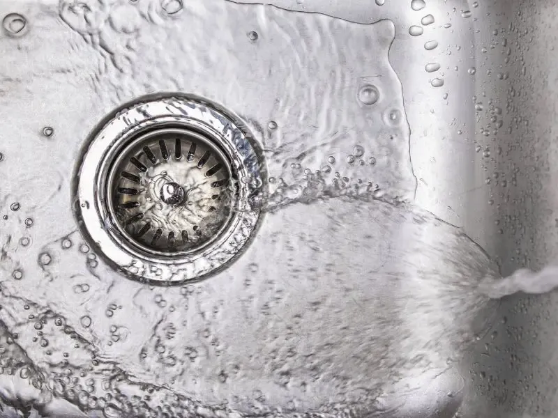 Gros plan d’un évier avec de l’eau s’écoulant vers le drain.